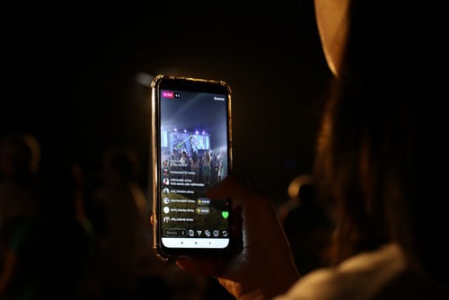 Person Recording a Live Performance with Her Cell Phone