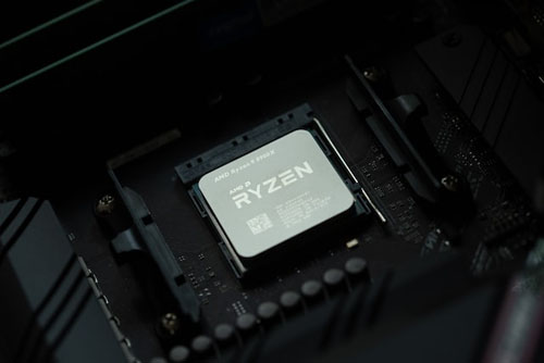An AMD Ryzen is seated onto a black motherboard