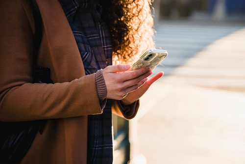 Woman texting on smartphone on street