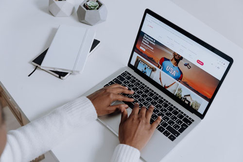 Person Using a Macbook Pro on a White Table