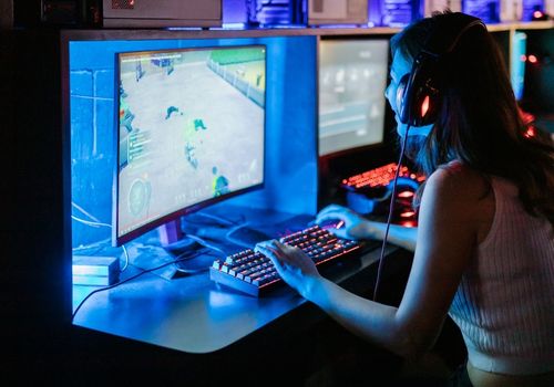 Woman Playing Computer Games With Headphones