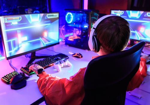 Gamer playing online game on PC in dark room