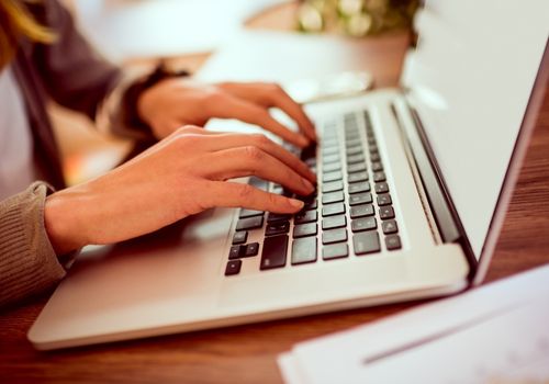 Female Hands Typing on the Laptop Keypad