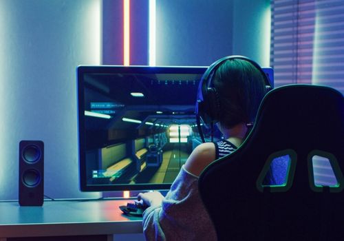 Girl with Headphones Playing an Online Game