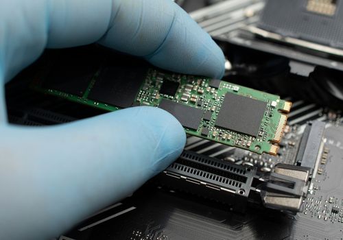 Technician Connects an SSD Hard Drive to a Motherboard