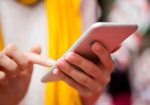 Woman with Yellow Scarf Using Her Smartphone