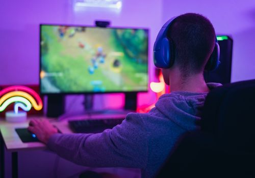 Young Man Playing a PC Game with Headsets On