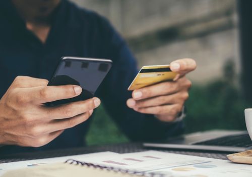 Person Holding a Mobile and Credit Card