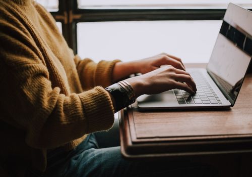 Person Sitting Infront of the Laptop