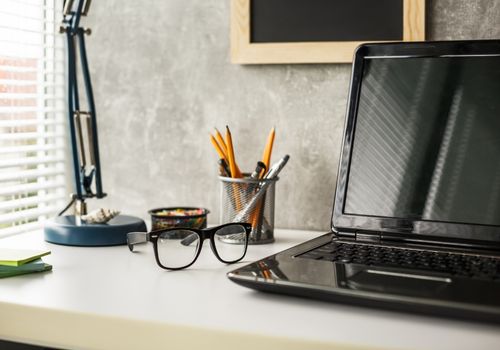 Turned off Laptop, a Pencil Holder, and Glasses on the Table