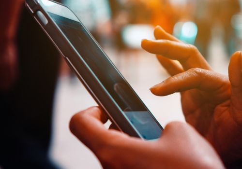 Woman's Hand Holding and Touching a Smartphone