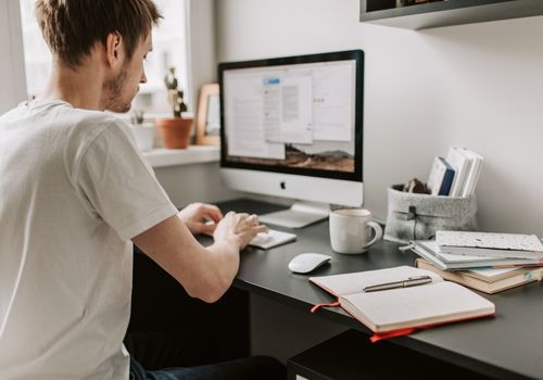 A Man Typing Something on His Mac Computer