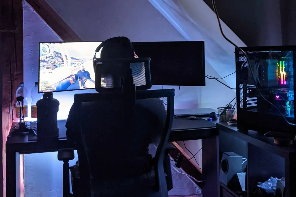 Back View of a Person Sitting on a Gaming Chair while Playing a Game