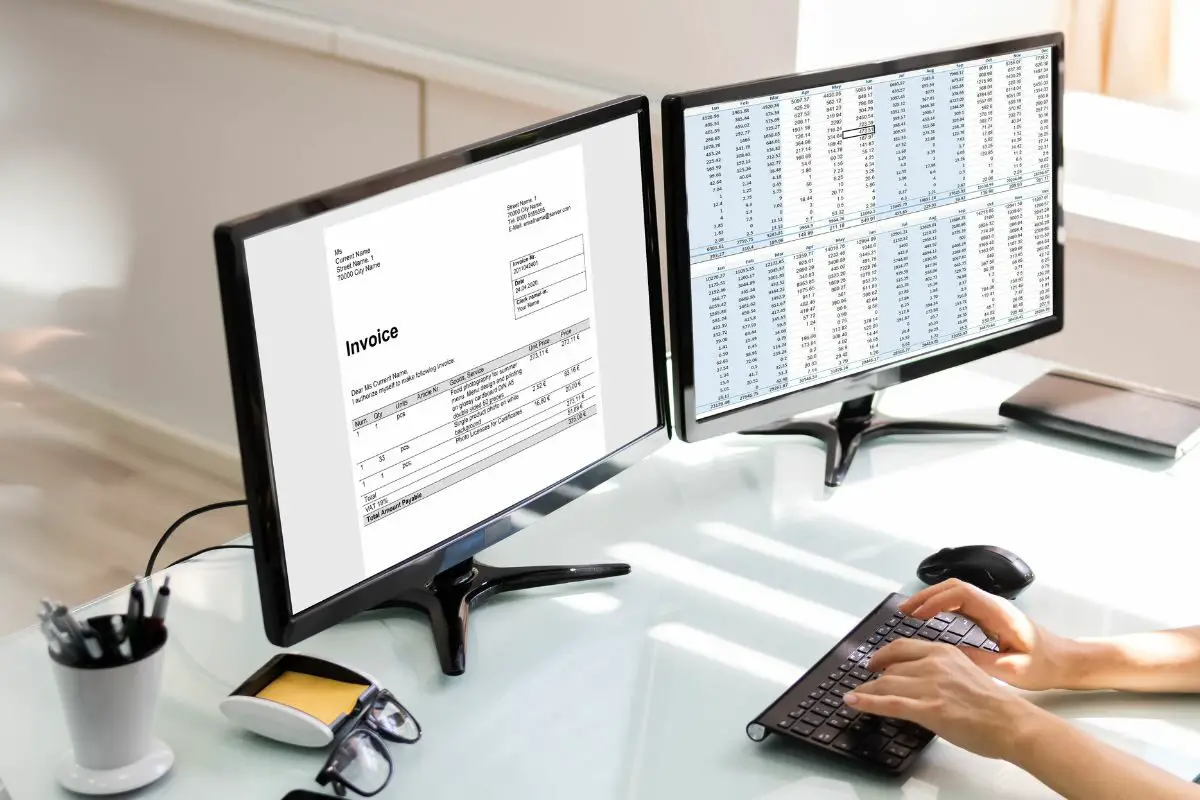 Accountant Making Invoice on Dual Monitor Setup