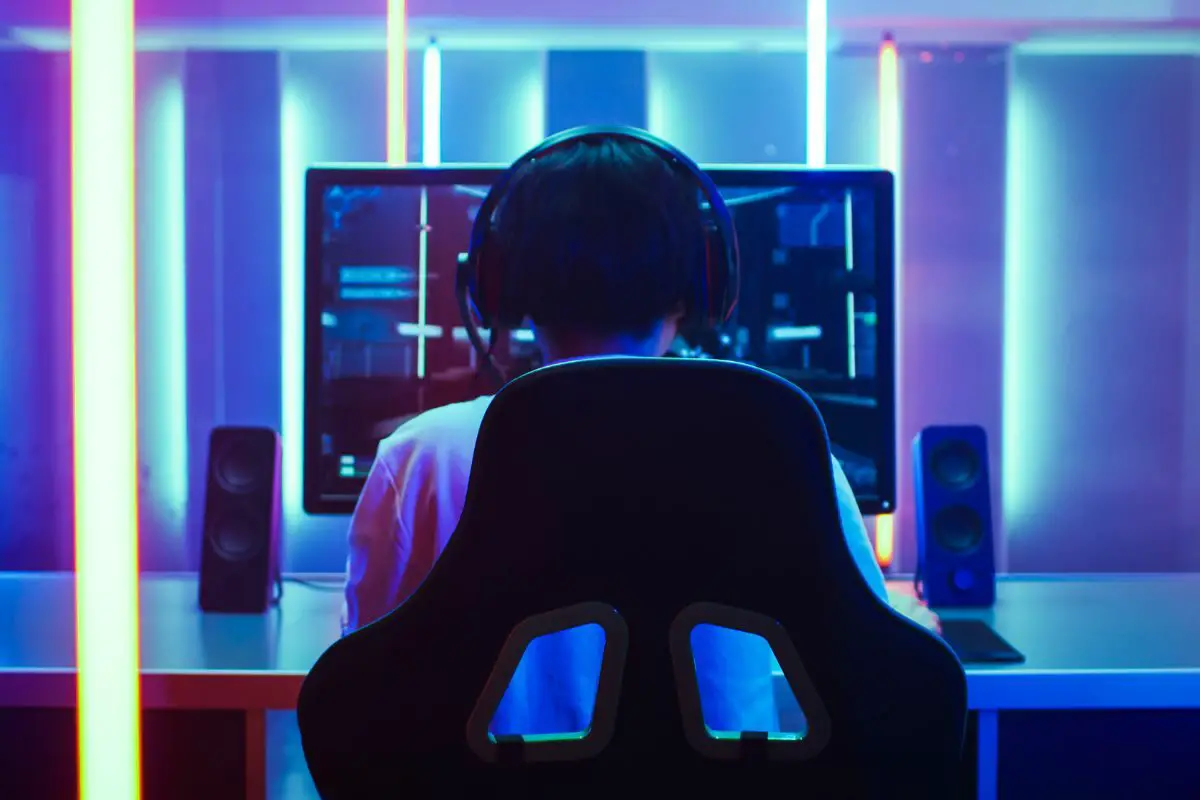 Back View Shot of a Gamer with Headphones Playing An Online Game