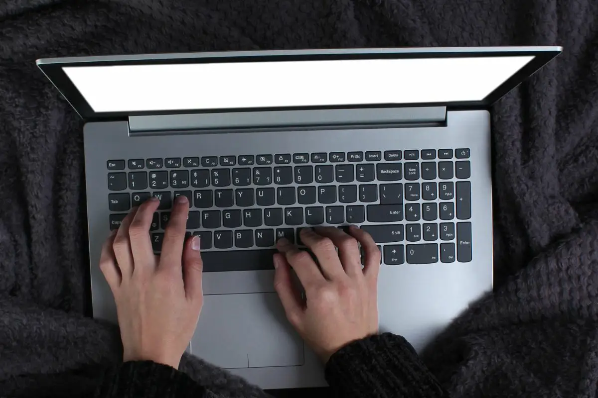 Female Wrapped in Blanket and Using Laptop on the Bed