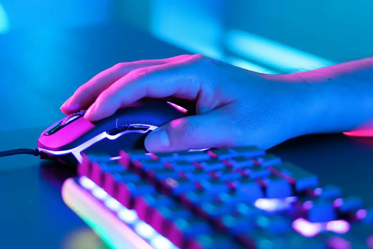 Man Clicking the Gaming Mouse beside a Modern Keyboard