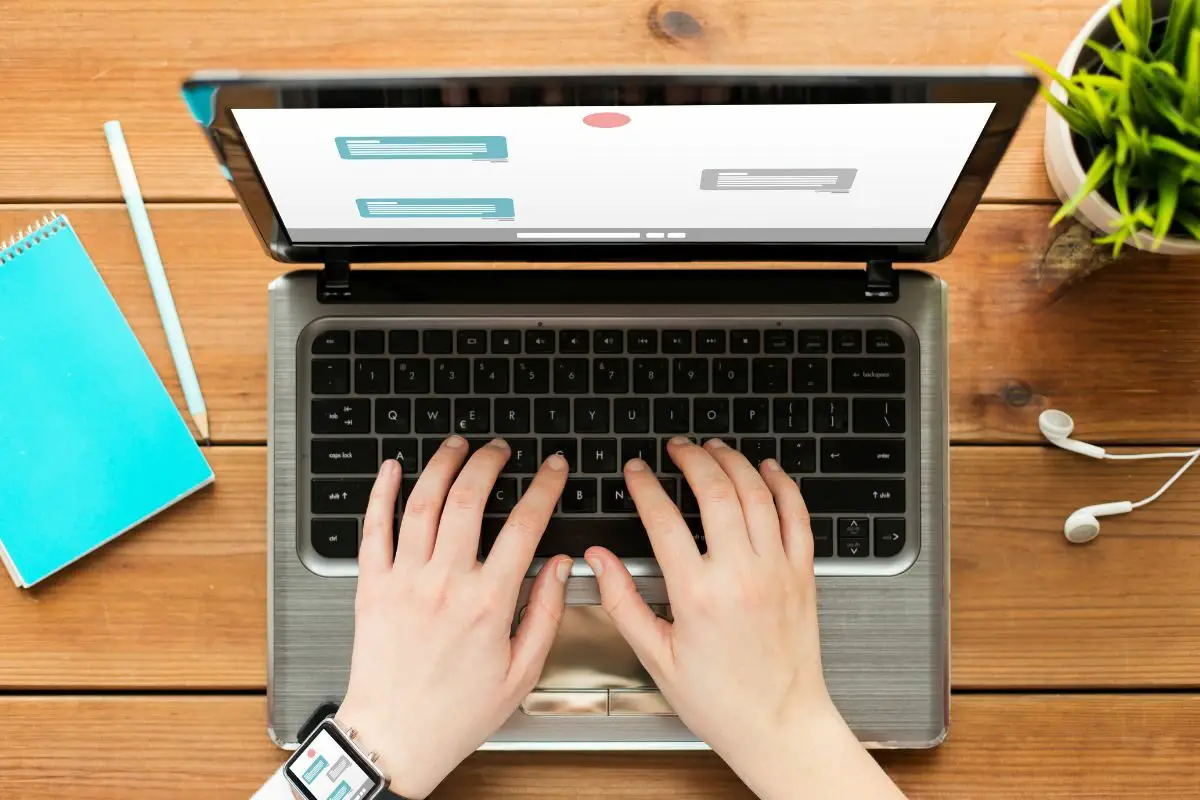 Person Using Laptop Placed on Top of the Wooden Surface