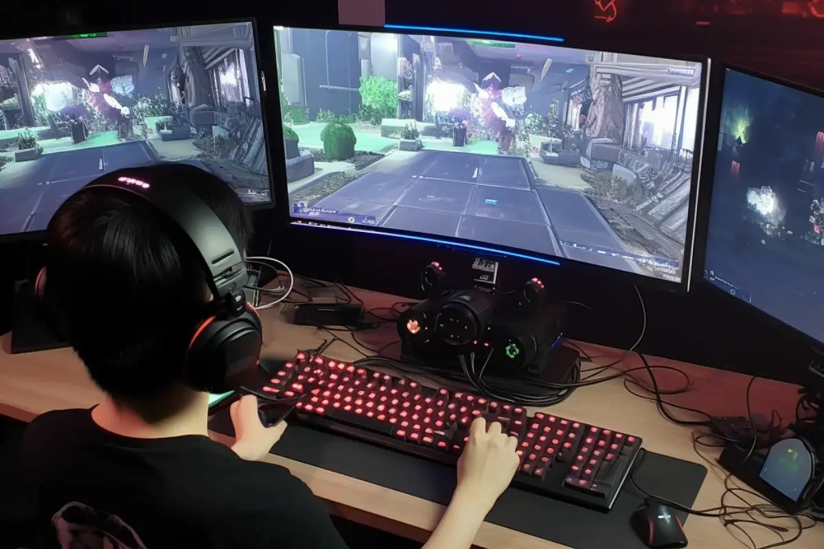 Teen Gamer Playing Online Game on Multiple Screen