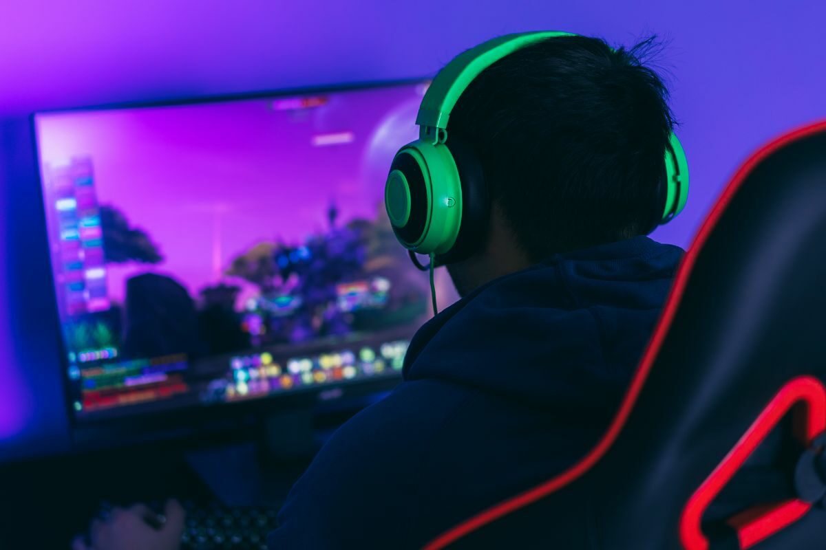 Young Man with Green Headphone Playing Live PC Game
