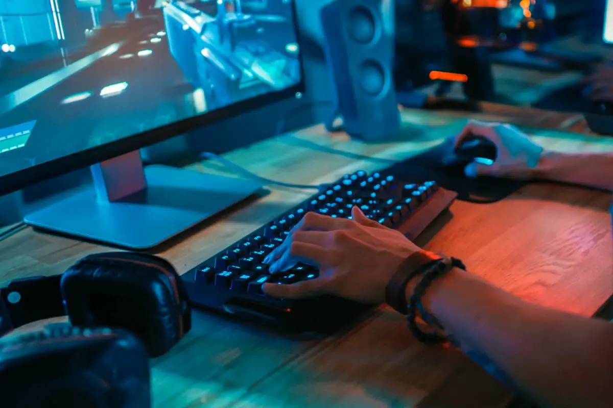 Gamer Using Keyboard While Playing Online Shooter Game