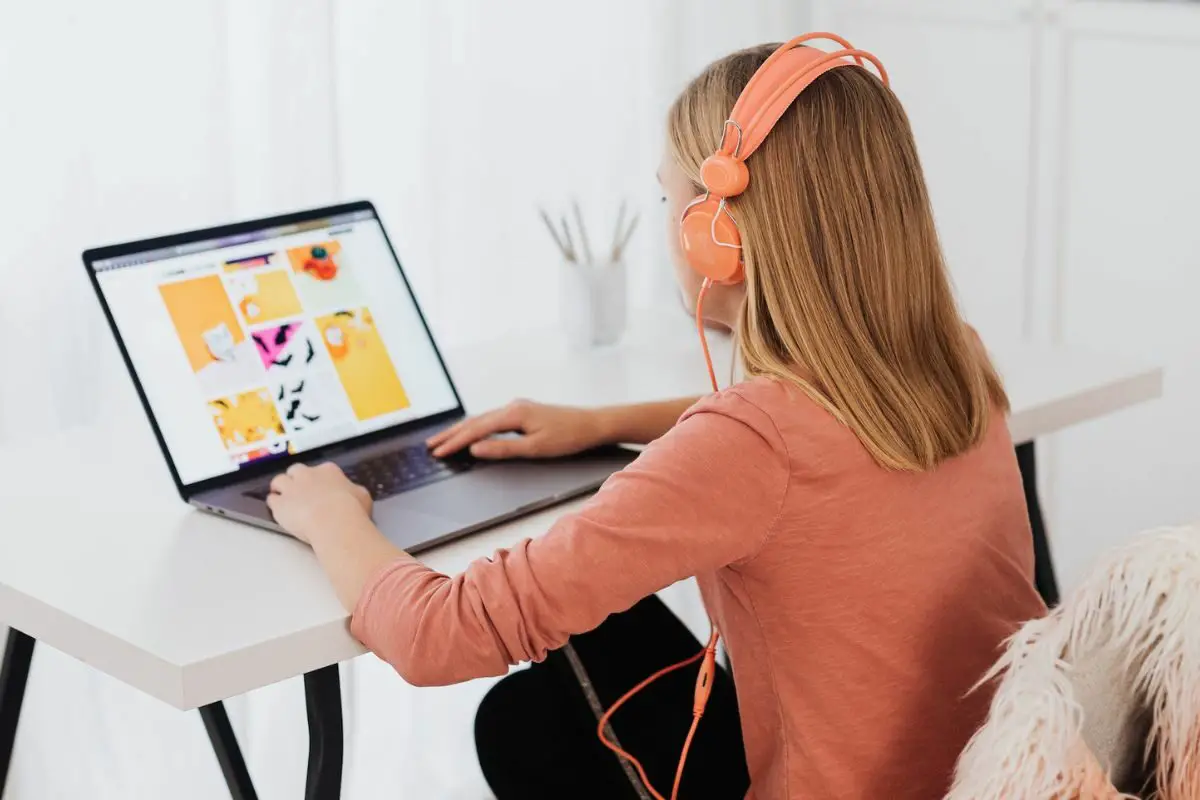 Girl Sitting at Desk and Using Laptop