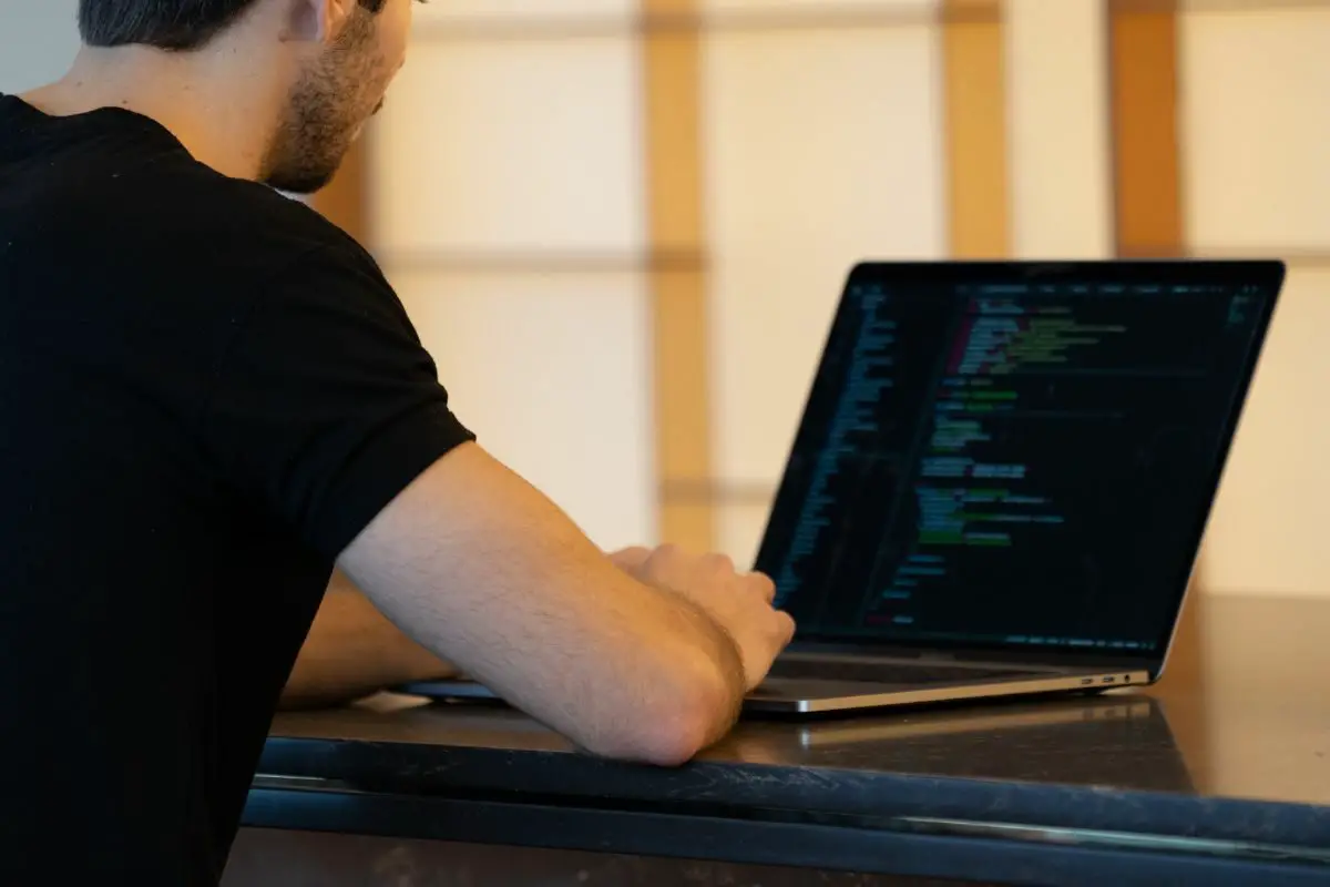 Man in Black T-shirt Working on the Laptop