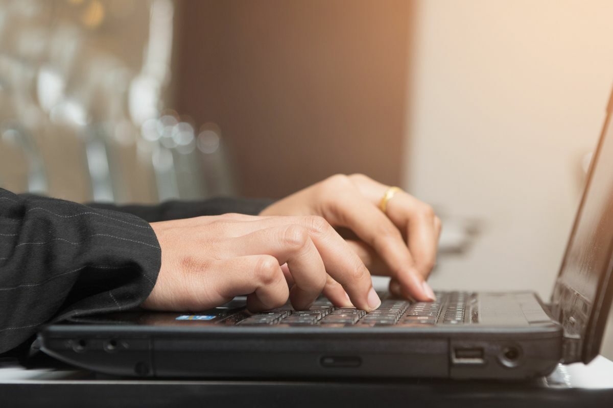 Person Typing on the Black Laptop Keypad