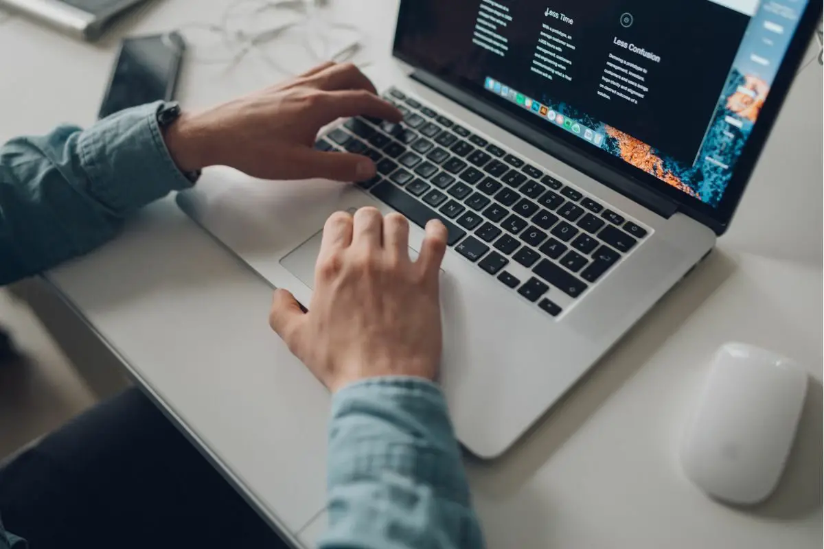 Person Wearing Long Sleeve Shirt Working on the Laptop