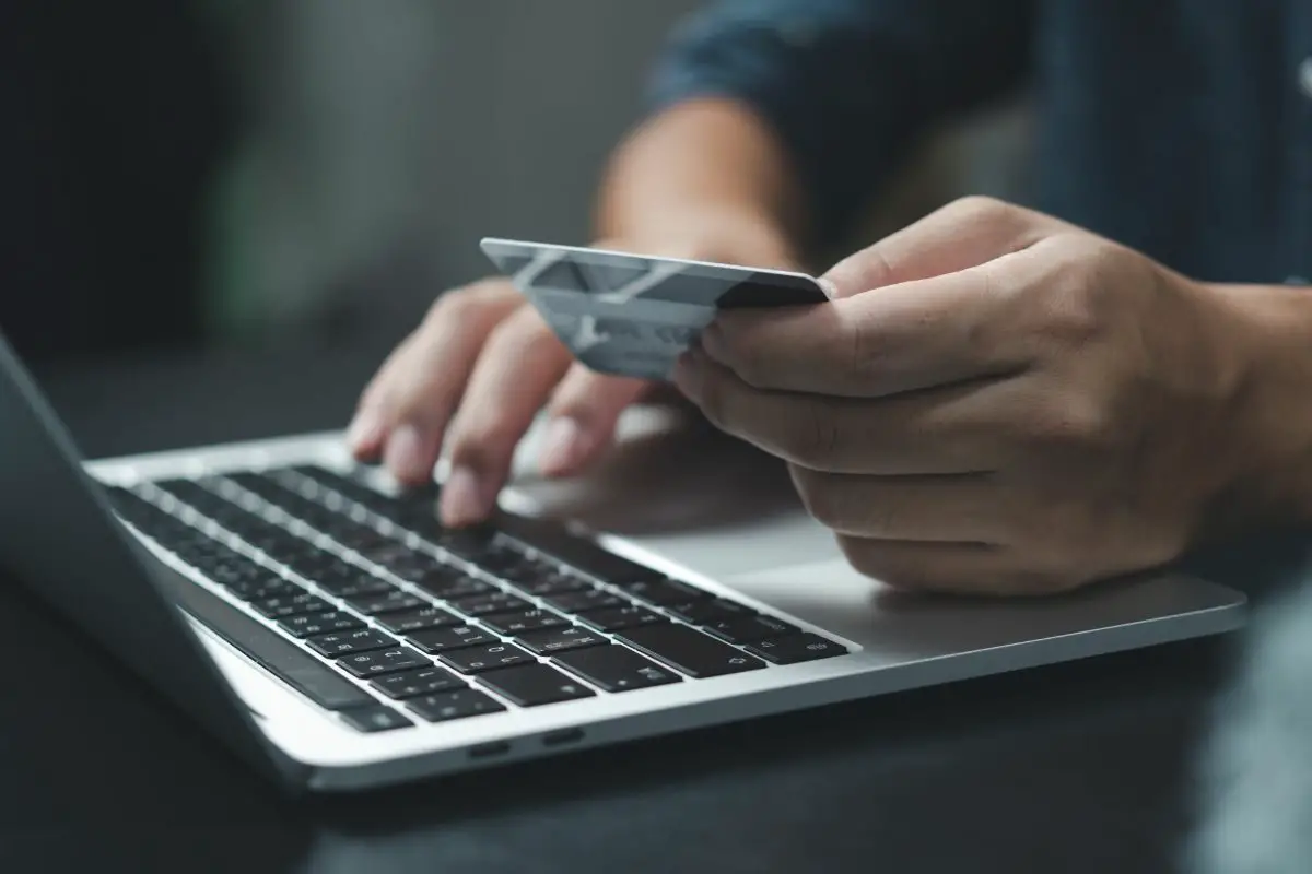 Person Working on Laptop While Holding a Card