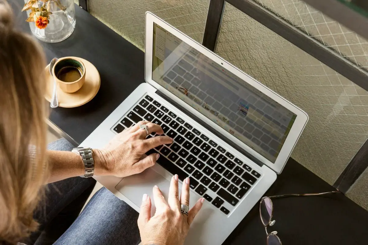 Person at the Café Working on the Grey Laptop