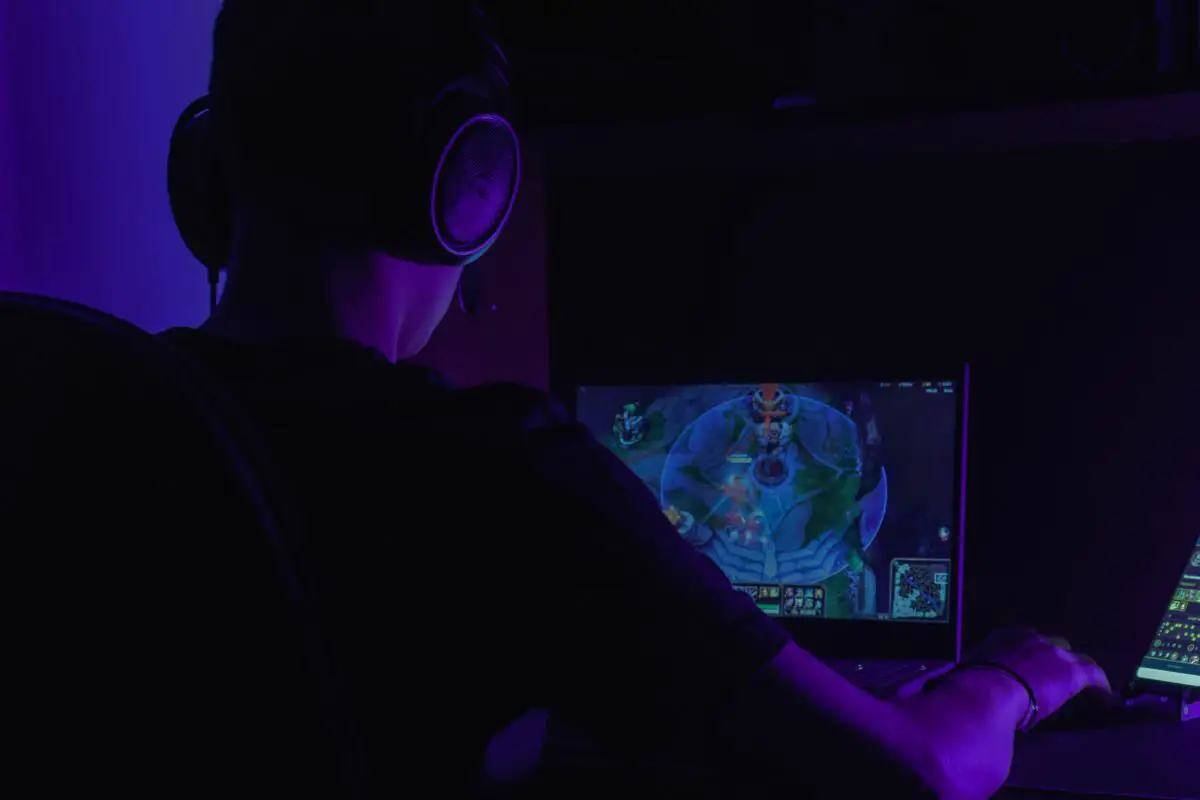 Person with Headsets Playing Game in Dark Room