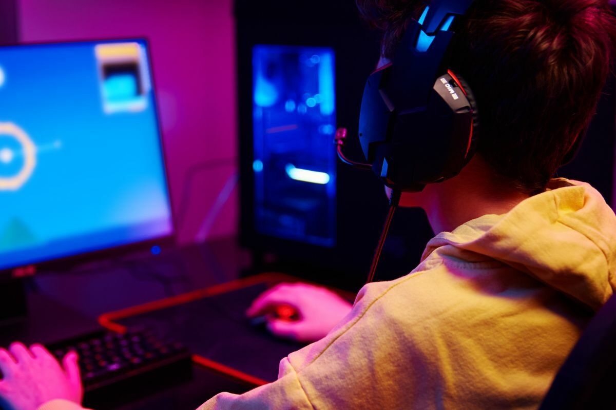 Teen with Headsets Playing Computer Game