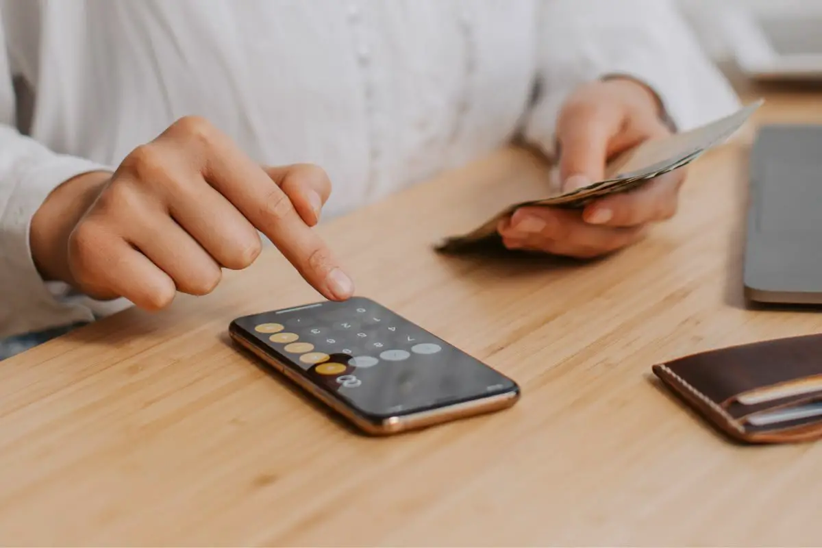 Woman Working on Mobile While Holding Some Cash