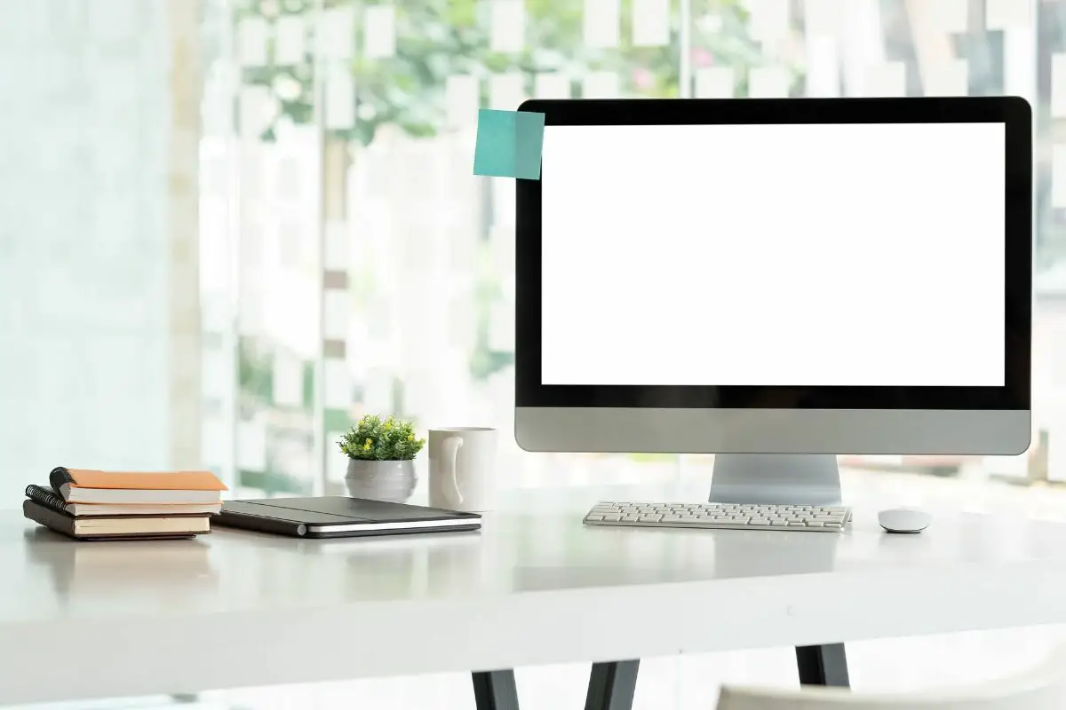 Computer Monitor and Notebooks on the White Table