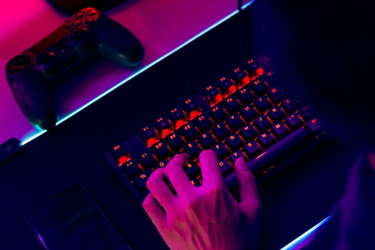 Male Player Playing Game Using RGB Keyboard