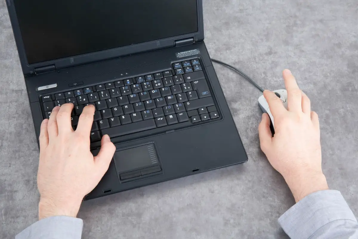 Man Working with Laptop while Using the Mouse