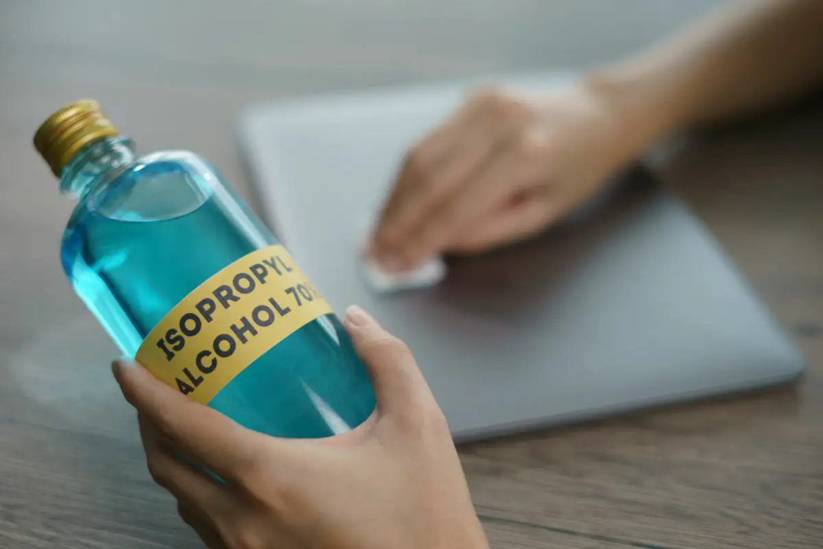 Person Cleaning Laptop with Isopropyl Alcohol