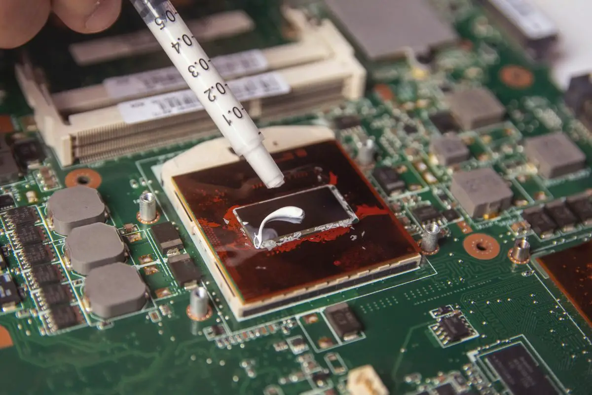 Technician Applying Thermal Paste on the Processor with a Syringe