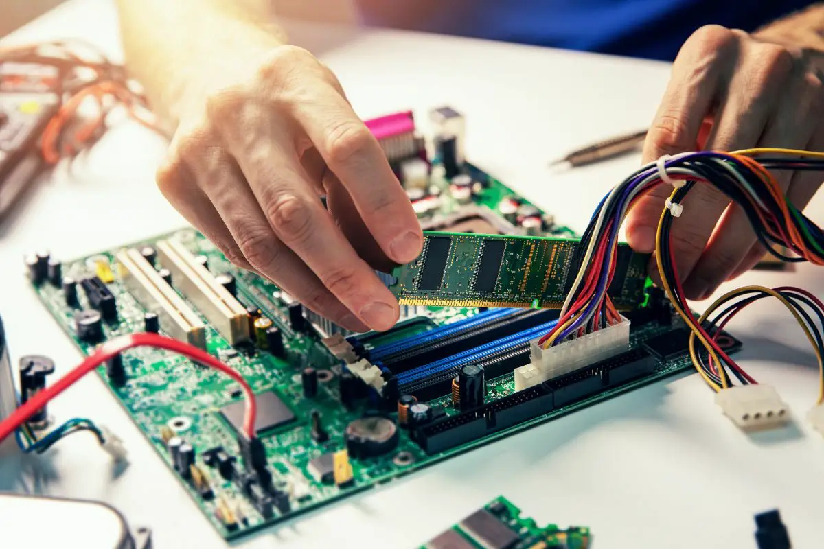 Technician Installing RAM Module On Motherboard