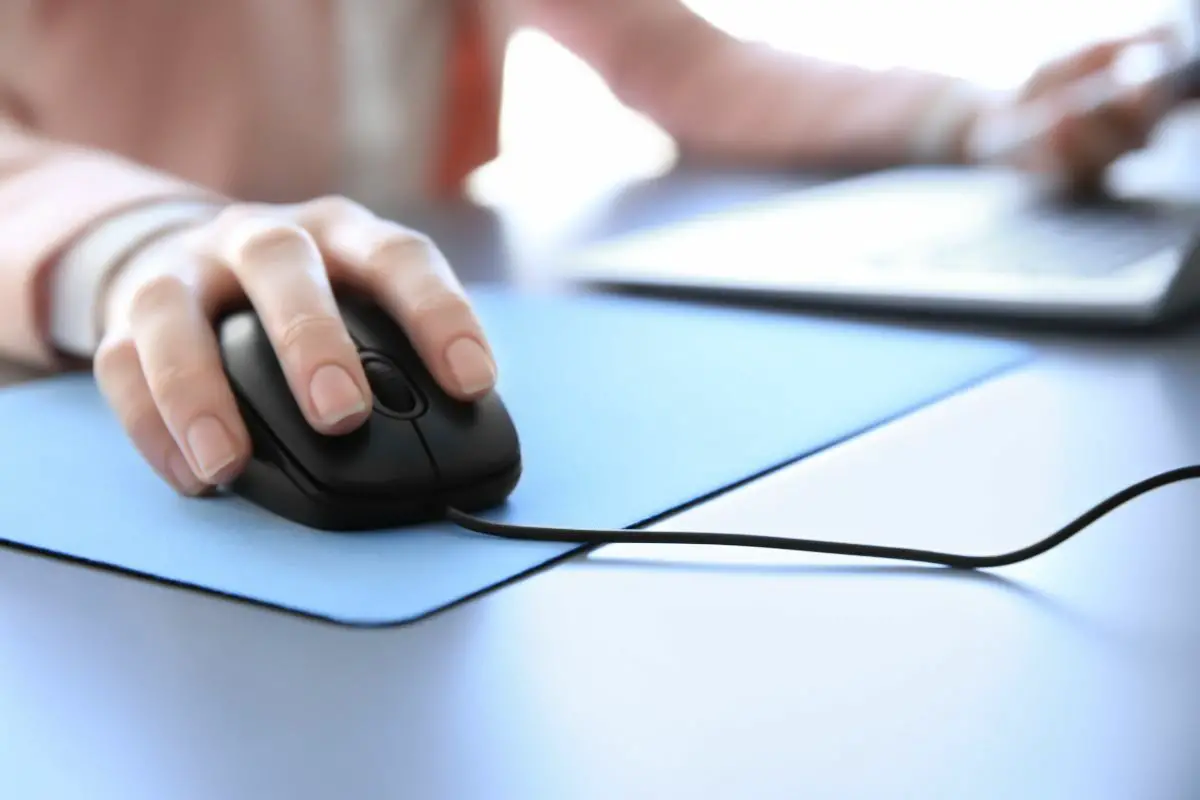 Woman Using a Mouse on a Blue Mousepad