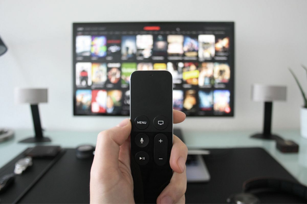 Man Holding a Remote in Front of TV