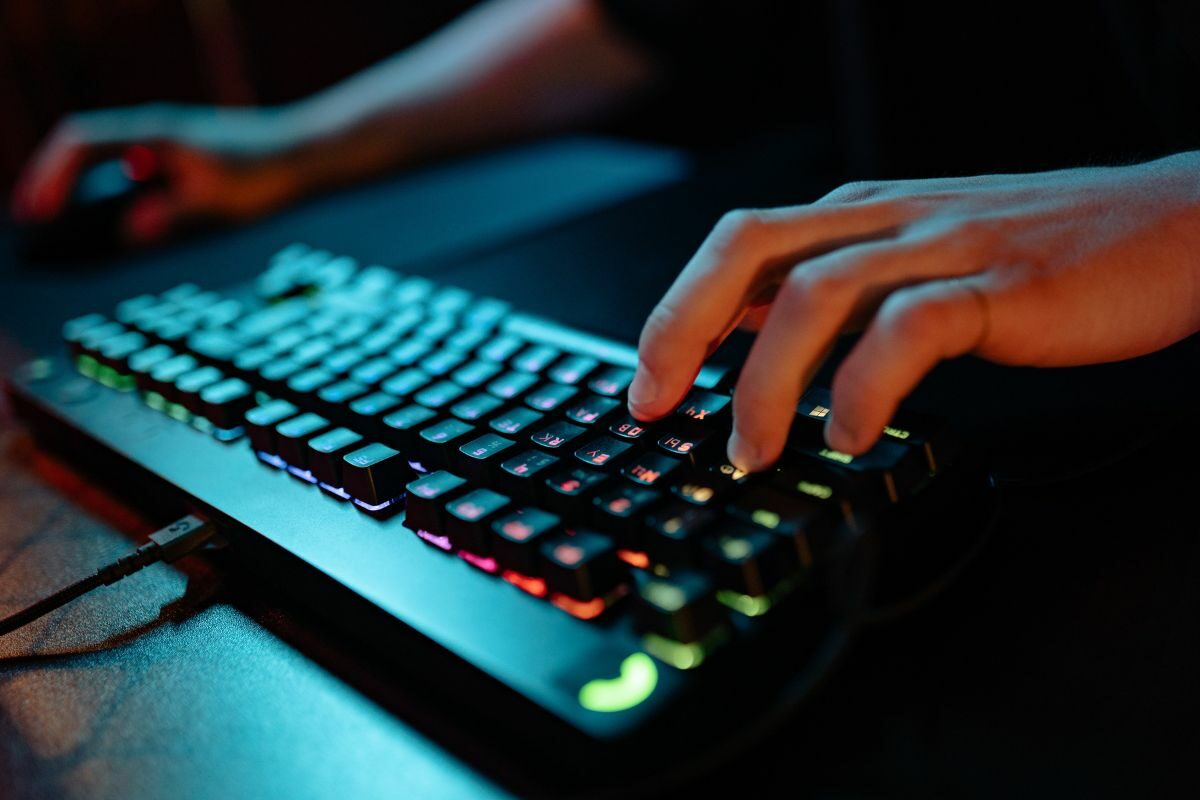 Person's Hand Typing on a Black Gaming Keyboard