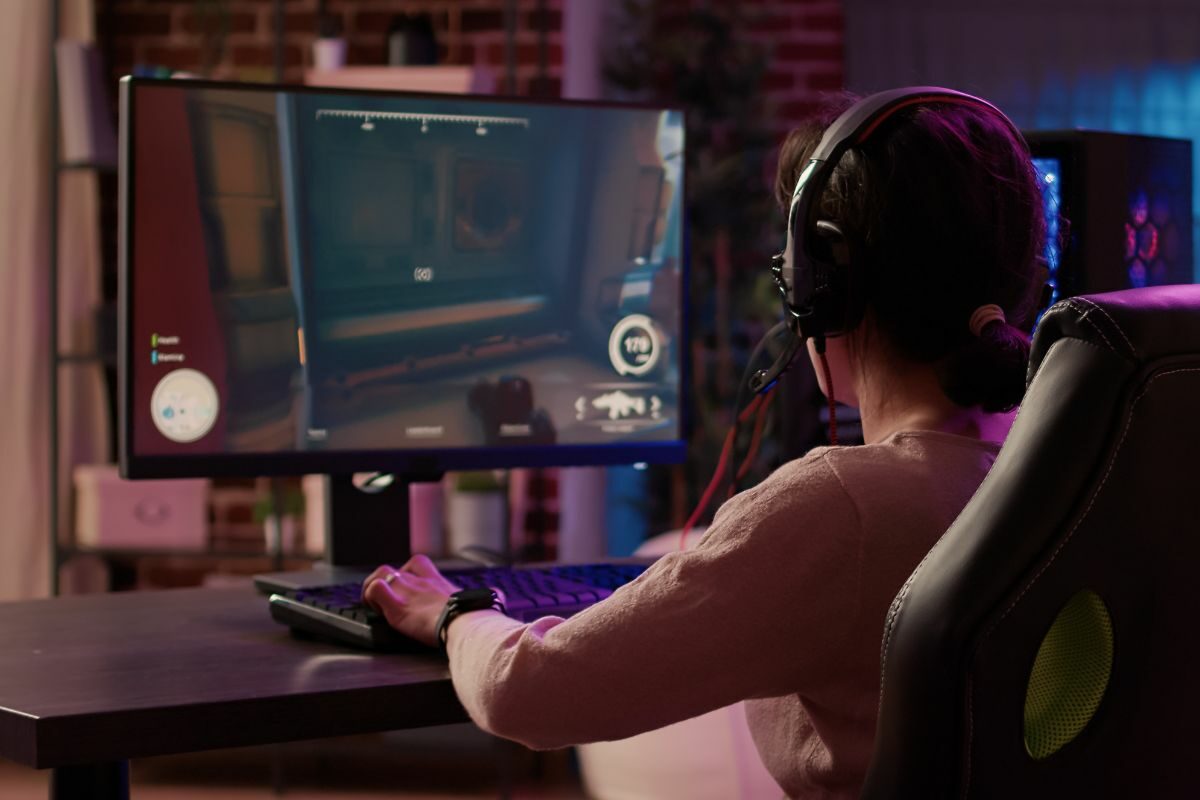 Girl Using Gaming PC Setup and Playing Online Multiplayer Shooting Game